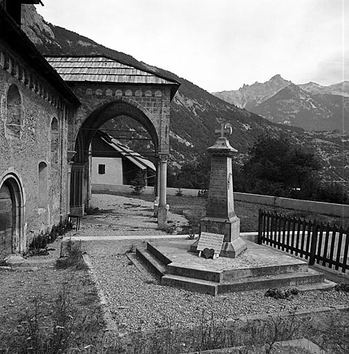 Le porche de l'église, le monument aux morts et l'ancien cimetière.
