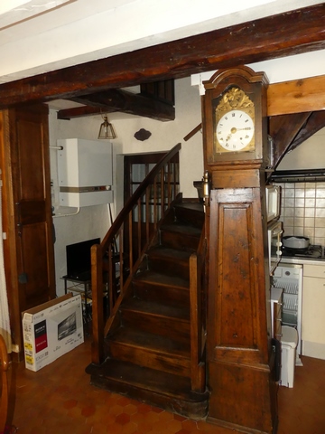 Rez-de-chaussée surélevé, cuisine. Départ de l'escalier et horloge.
