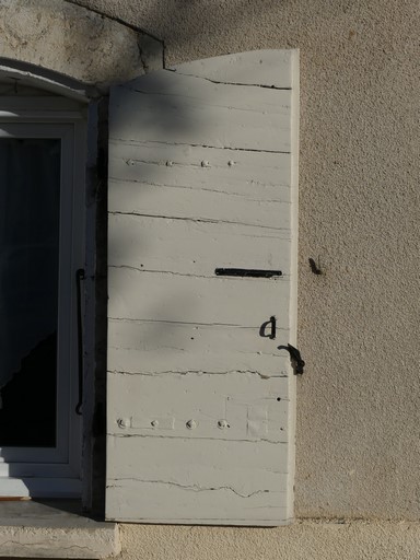 Fenêtre équipée de contrevents à planches croisées. Maison située place de la Fontaine au bourg de Ribiers (parcelle 1998 E2 641).
