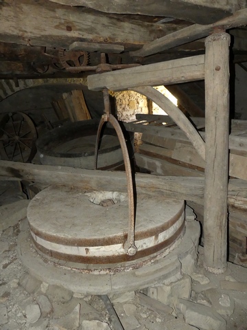 Bâtiment principal. Etage de soubassement, meunerie. Meule orientale avec son bras de relevage.