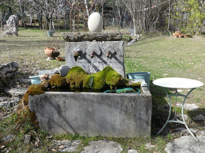 Fontaine, dont le buffet compte trois canons en fonte et porte des dates et initiales gravées : 1700 / 1934 / AA / IA. Ferme de Riousset (Ribiers).