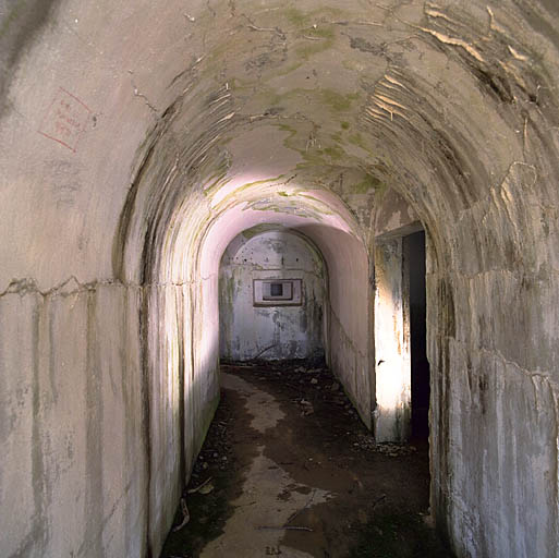 Ouvrage d'artillerie dit batterie Monte Agnelino : couloir d'entrée avec embrasure d'axe d'une casemate d'action frontale, à droite, réserve.