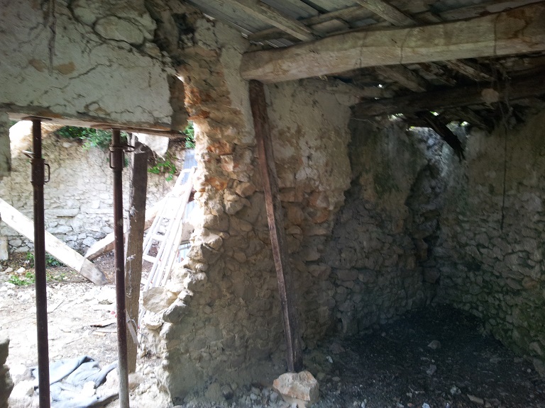 Bergerie. Mur cloisonnant les deux espaces à l'intérieur de l'entrepôt agricole, avant les travaux de 2012.