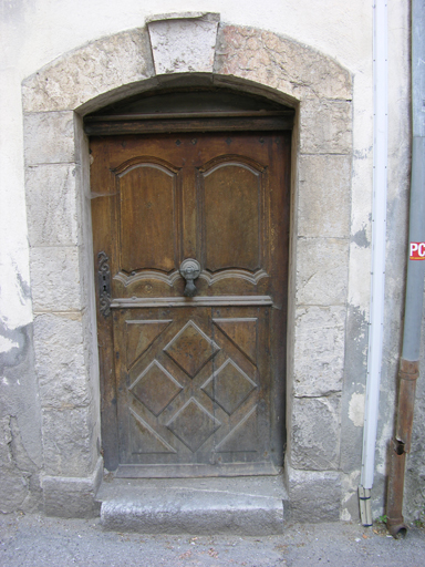 Barrême, parcelle H285. Porte du 18e siècle à encadrement en arc segmentaire et vantaux moulurés.
