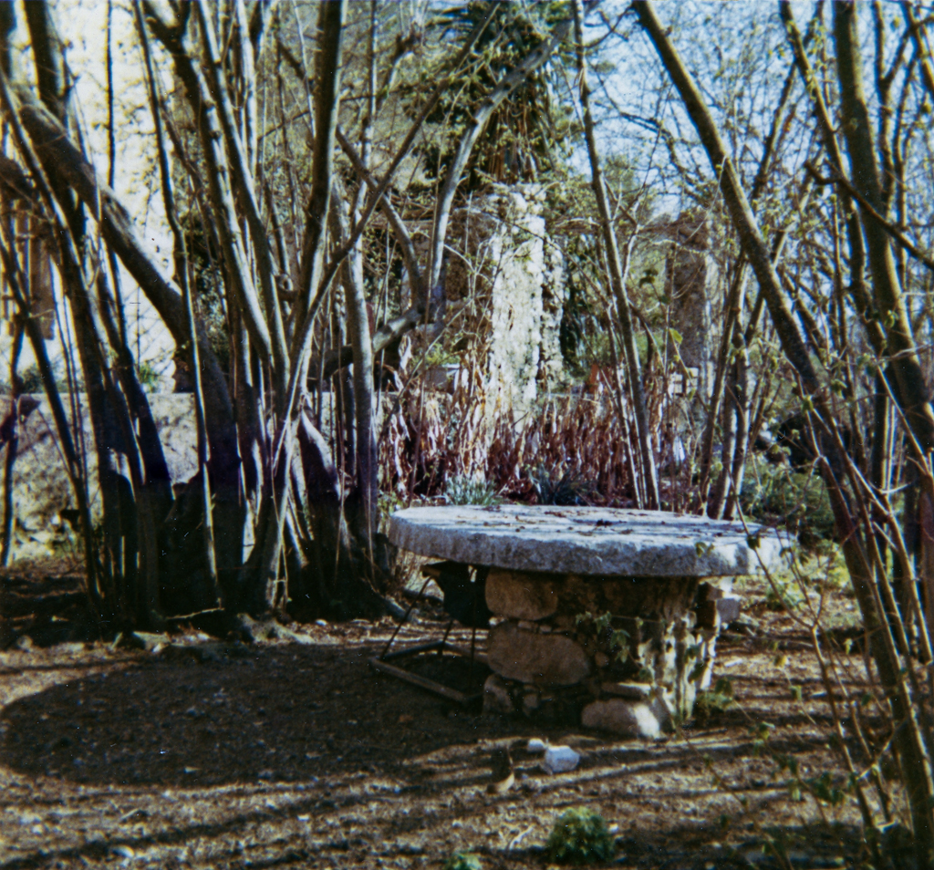 Jardin à l'ouest de la ferme. Ancienne meule réutilisée en table de jardin. Vue prise du nord-ouest. Etat vers 1970.