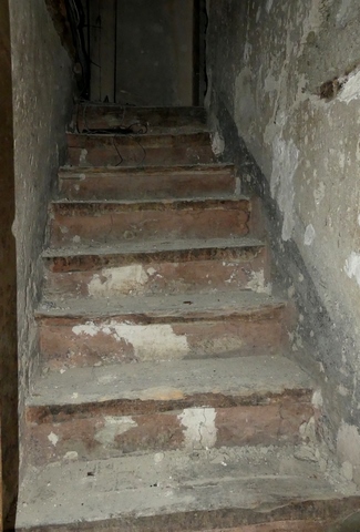 Rez-de-chaussée surélevé, escalier menant à l'étage.