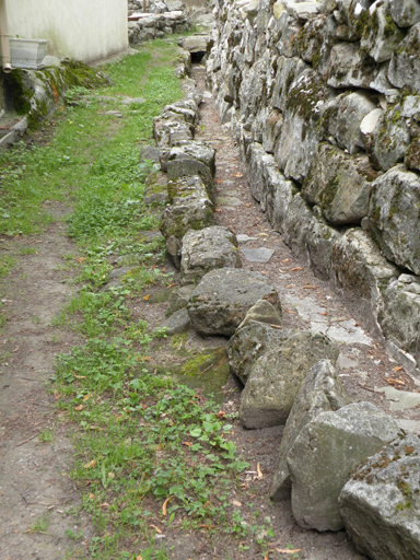 Rue du hameau de Chabrières, bordée par le canal d'arrosage.