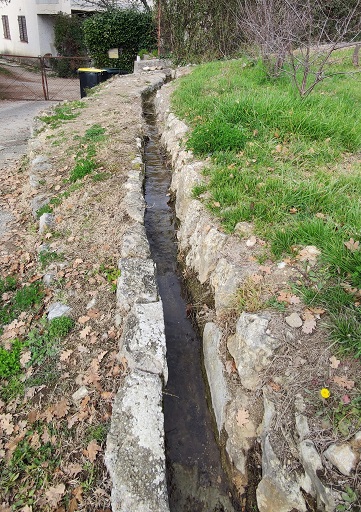 Quartier des Conques. Canal d'irrigation le long du chemin des Condamines en pierres calcaires. 
