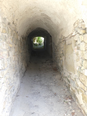 Passage couvert longeant le côté ouest de la maison, vue de volume prise du sud.