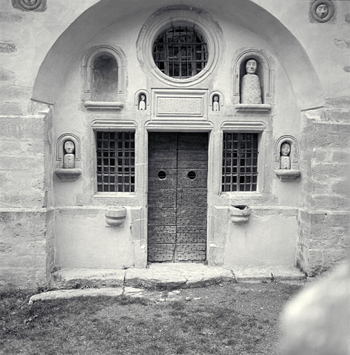 Décor d'élévation extérieure : statues (9), sculptures (masques, 7), porte, fenêtres (2), oculus, tronc, bénitier