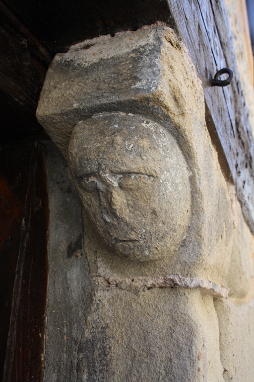 Détail d'une tête sculptée en grès, orientée à l'est.