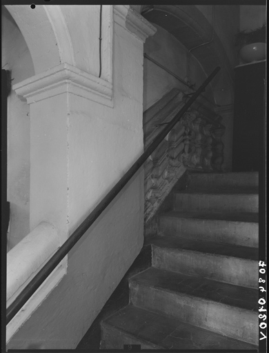 Escalier, première volée, arc muré et rampe à balustres.