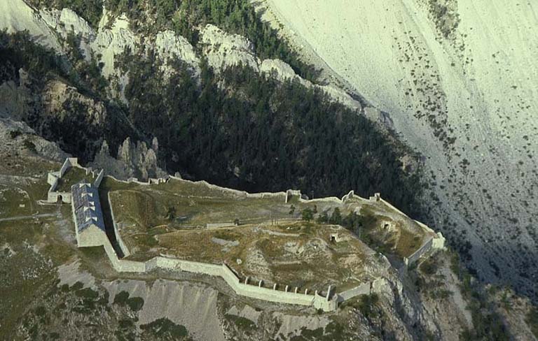 Vue aérienne d'ensemble prise de l'est. Au premier plan, au pied des escarpements, la baraque défensive du Pas du Berger.