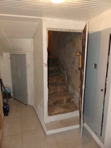 Couloir desservant l'escalier menant au sous-sol (au fond) et celui desservant l'étage. Maison située Grand'Rue au bourg de Ribiers (parcelle 1998 E2 606).