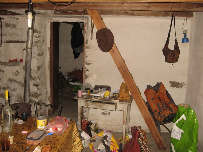 Cabane de Juan. La pièce commune donne accès à une seconde pièce et au dortoir à l'étage de comble, grâce à un escalier intérieur.