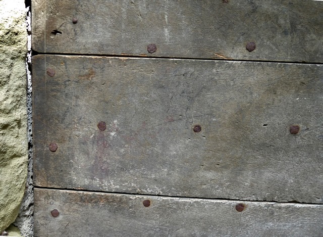 Détail de la menuiserie d'une porte, entrepôt agricole au bourg.