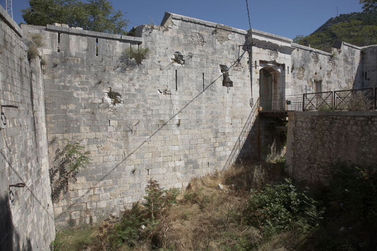 Front d'entrée sud (1-2) courtine crénelée à décrochements, fossé, porte à pont-levis.
