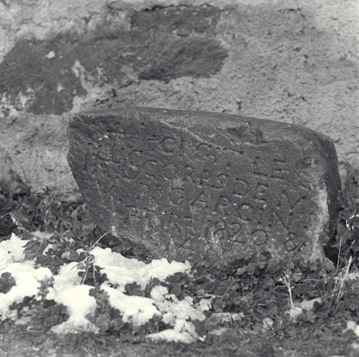 Pierre tombale de l'ancien cimetière déposée près de l'entrée de l'église.