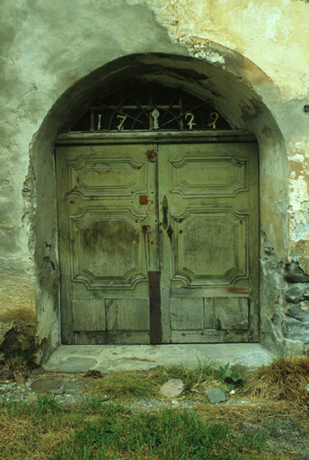 La porte de la court. La ferronnerie de l'imposte indique la date 1729. La fleur de lys au centre a été bûchée.