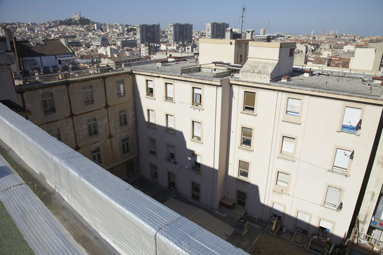 Cour intérieure. L'aile secondaire, à droite, est reliée par une aile de galeries superposées (à gauche).