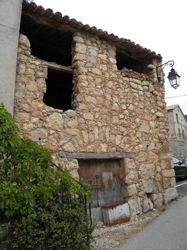 Le Touron, façade sud d'un entrepôt agricole situé dans un îlot de bâtiments mitoyens (B2 595).