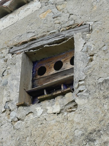 Bâtiment du pigeonnier. Pignon est, deuxième niveau. Baie d'envol du pigeonnier, avec grille en menuiserie.