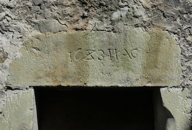 Elévation ouest, premier niveau. Porte sud, linteau avec date (1683) et initiales (I I A G) gravées.