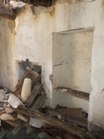 Rez-de-chaussée surélevé, logis. Mur ouest, cheminée et placard-niche.