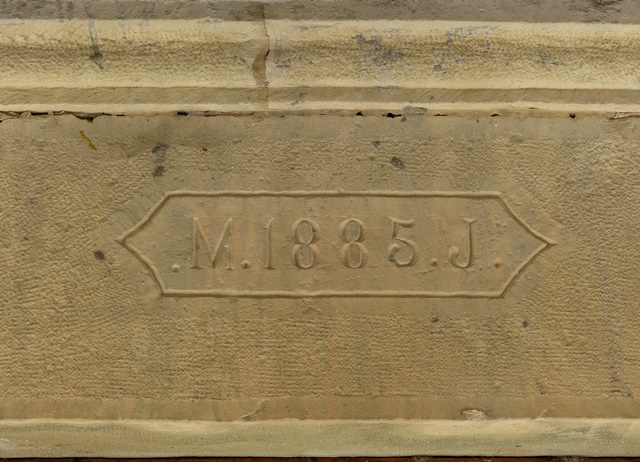 Elévation sud, premier niveau. Porte du logis : date gravée (1885) accompagnée d'initiales (M J).