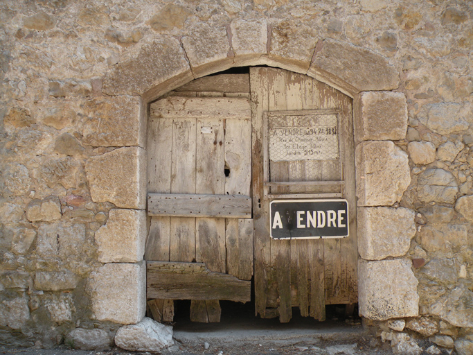 Village, 5e maison. Porte de remise avec encadrement en pierre de taille en arc segmentaire.