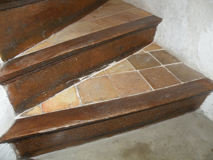 Le village, parcelle A2 284. Détail des marches d'un escalier : marches en carreaux de terre cuite, nez-de-marches en bois et contremarches en bois.
