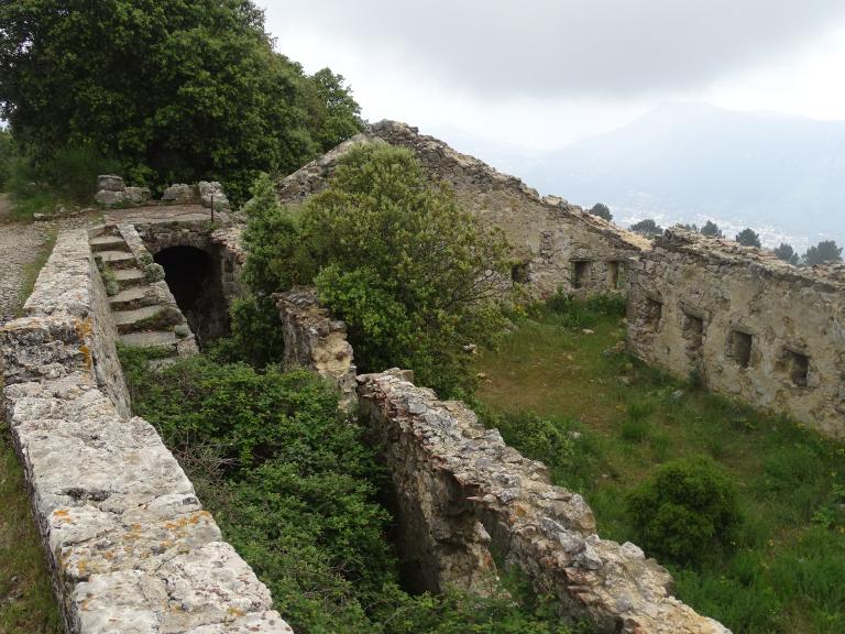 Ruines du baraquement crénelé hors enceinte en contrebas du chemin, avec son escalier d'accès.