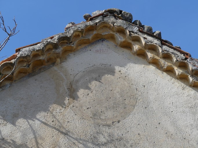 Décor d'oculus et de frise sous génoise ; date et initiales peintes : 1871 J B. Bâtiment au quartier du Champ de la Dame (Ribiers).