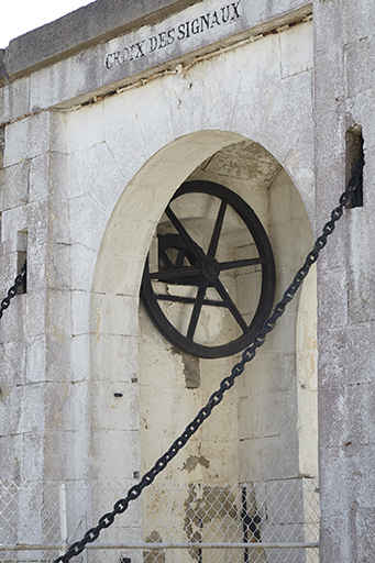 Porte à pont-levis du fort, détail de la façade vue obliquement montrant le sas et la roue de guidage.