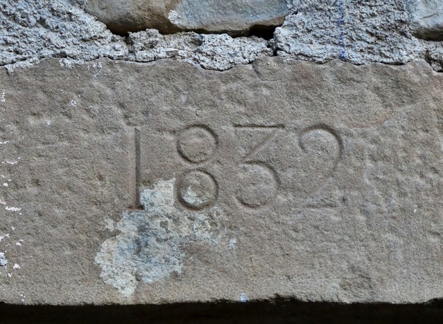 Bâtiment du logis. Elévation ouest, premier niveau. Fenêtre du logis avec linteau portant la date gravée 1832.