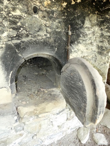 Rez-de-chaussée, four à pain. Bouche du four avec porte monolithe.
