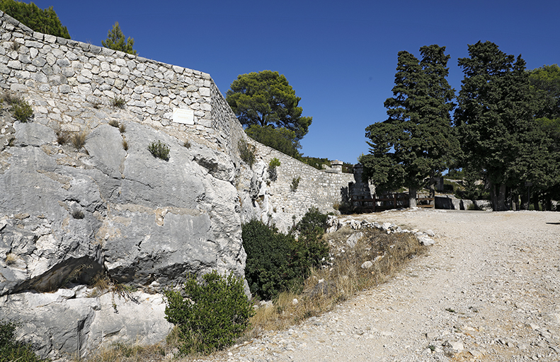 Mur-parapet du front de gorge greffé sur le rocher dans le secteur ouest, fossé.