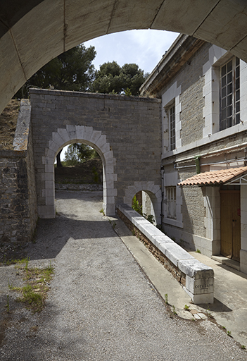 Passage d'entrée de la porte à la cour, mur-parados à arcade entre grand cavalier et culée gauche de la caserne.