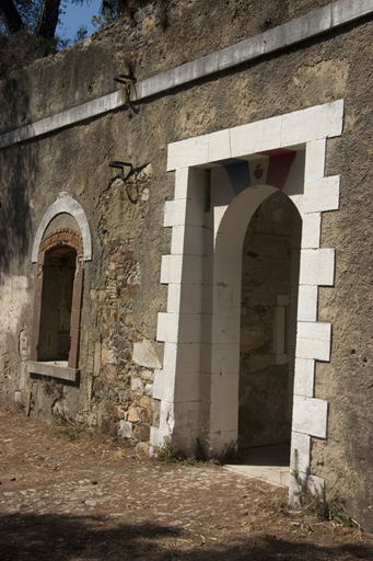 Tour-réduit crénelée, façade d'entrée, porte à tableau de pont-levis donnant sur le sas d'entrée.