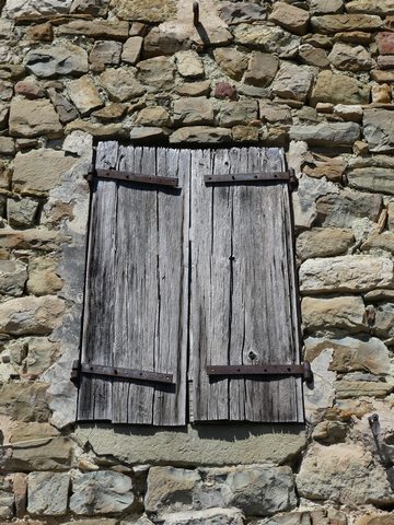 Elévation est, deuxième niveau. Fenêtre surmontée d'un arc de décharge, et équipée de contrevents en planches croisées.