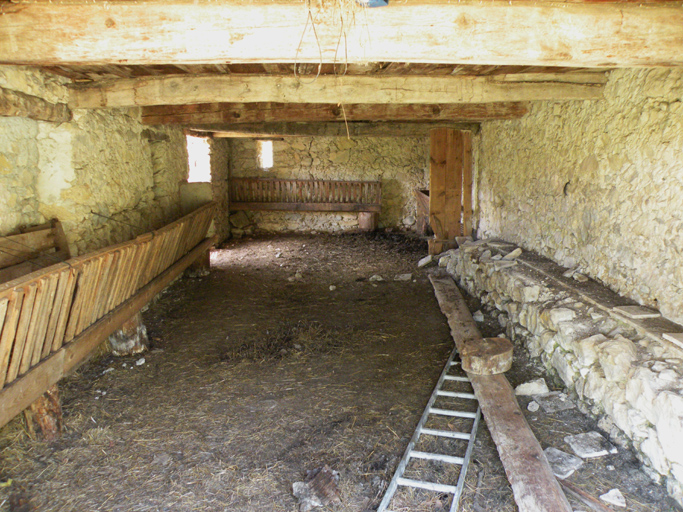 La Bastide, vue de volume d'une étable avec une banquette de mangeoire et des râteliers, 1988 E1 19.