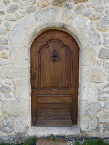 Porte de logis avec encadrement en arc plein-cintre chanfreiné ; menuiserie moulurée. Ferme de Chaudon (Ribiers).