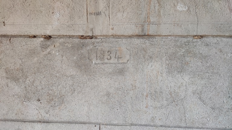 Bâtiment du logis, unité orientale. Etage de soubassement, pièce agricole multifonctionnelle. Angle sud-ouest, cuve vinaire en béton. Date gravée : 1934. 
