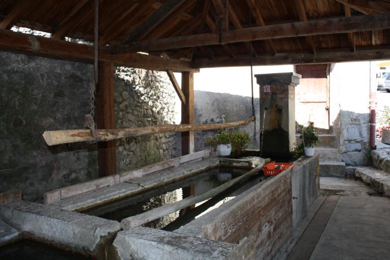 Thorame-Haute. Lavoir public sur la place principale du village. Au premier plan, la tringle suspendue à la charpente, au-dessus d'un bassin.