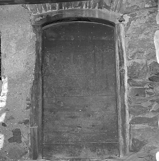 La porte de la cuisine est couverte d'un linteau en bois cintré surmonté d'une plate-bande en moellons.