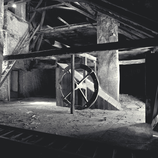 Etage sous comble. Vue d'ensemble avec la roue du treuil et la montée d'escalier.