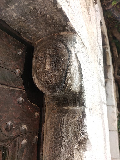 Elévation ouest, premier niveau. Porte du logis, piédroit sud avec le coussinet orné d'une tête sculptée. 