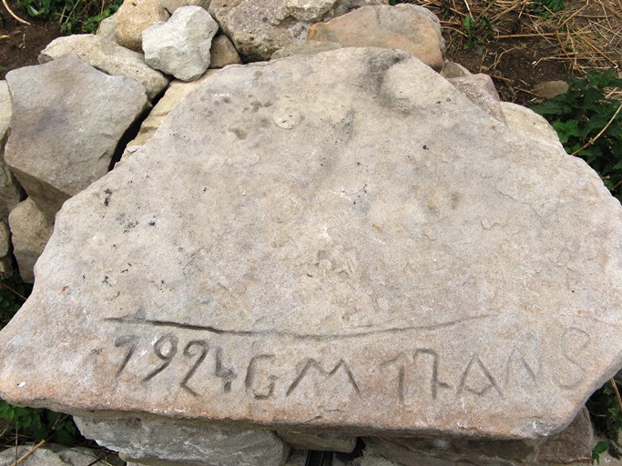 Cabane de Juan. Pierre portant une inscription sur la fontaine ("1924GM17ANS") témoignant de la présence ancienne de l'activité pastorale sur place.