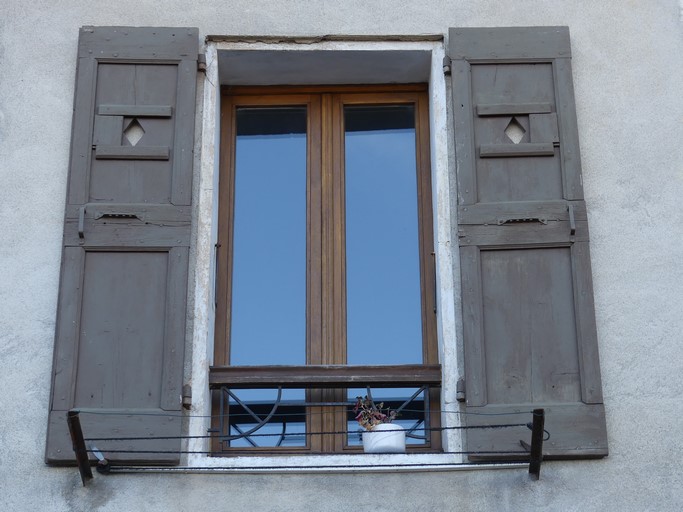 Fenêtre équipée de contrevents à cadre, avec jours en losange fermés par un œilleton coulissant. Maison située route de Laragne au bourg de Ribiers (parcelle 1998 E2 747).
