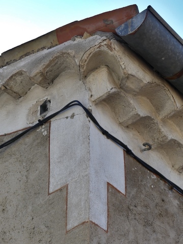 Bâtiment du logis. Angle nord-ouest, décor peint et passage en éventail de la génoise de l'avant-toit vers la saillie de rive.
